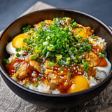 Ein Schalen mit Oyakodon, das eine Mischung aus Rindfleisch, Eiern und Zwiebeln ist.